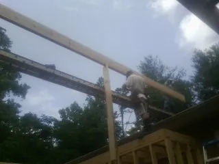 Carpenter setting a ridge beam over a new addition frame — Ice Dam Removal by Roofing Brothers in South Lyme
