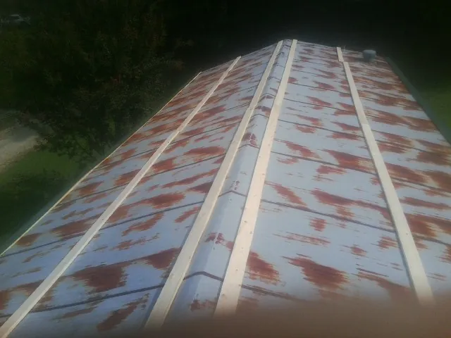 Rusted metal roof panels with new wood purlins before replacement — Storm Damage Roof Repair in South Lyme by Roofing Brothers