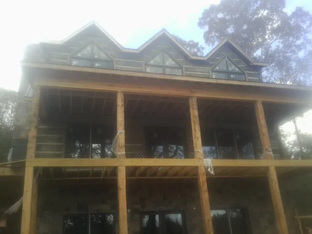 Dormers and porch framing on a large log home under construction — Roof Coating work by our crew in South Lyme