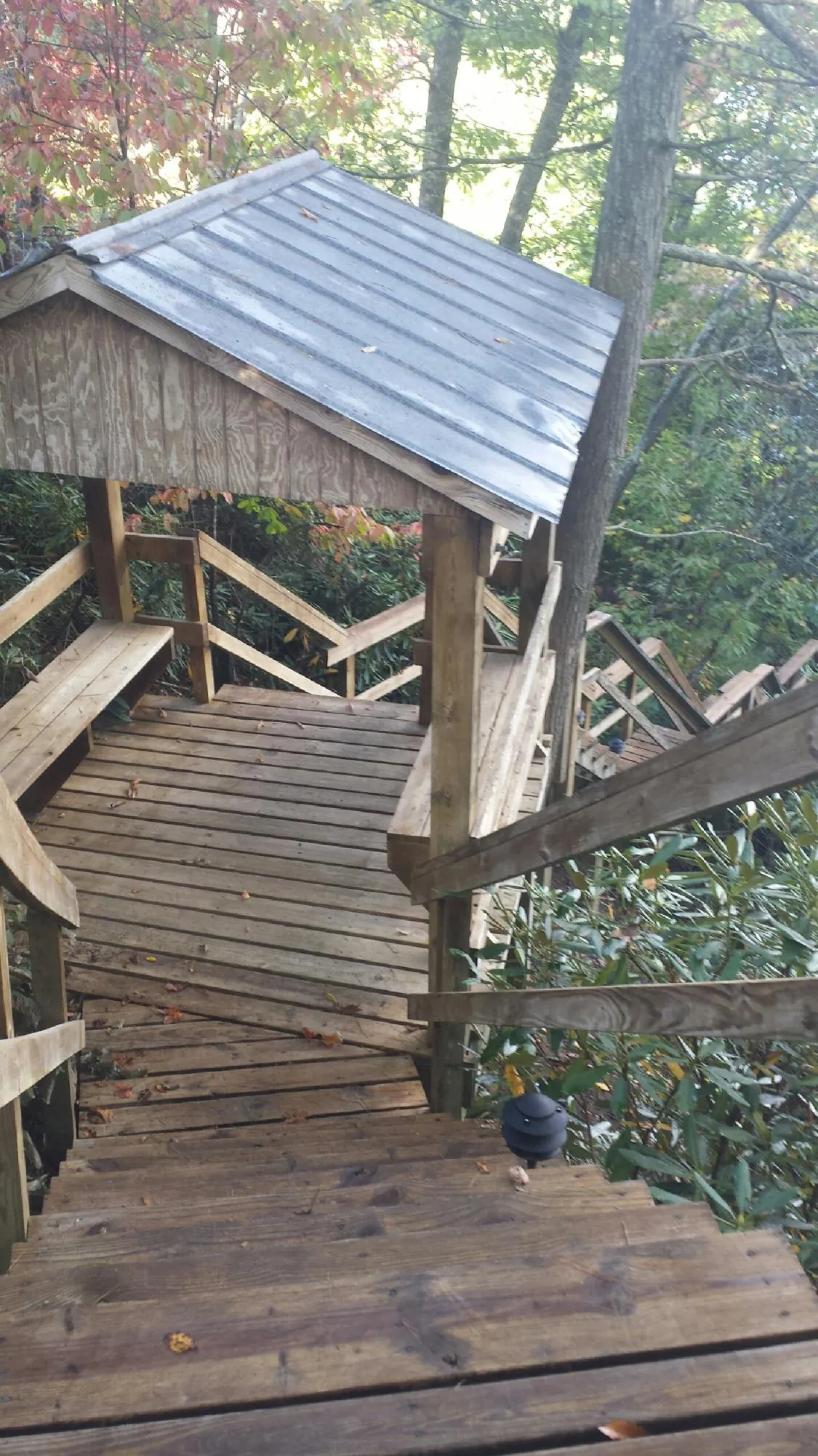 Metal roofed shelter over wooden steps on a wooded walkway — Skylight Repair & Installation work by our crew in South Lyme