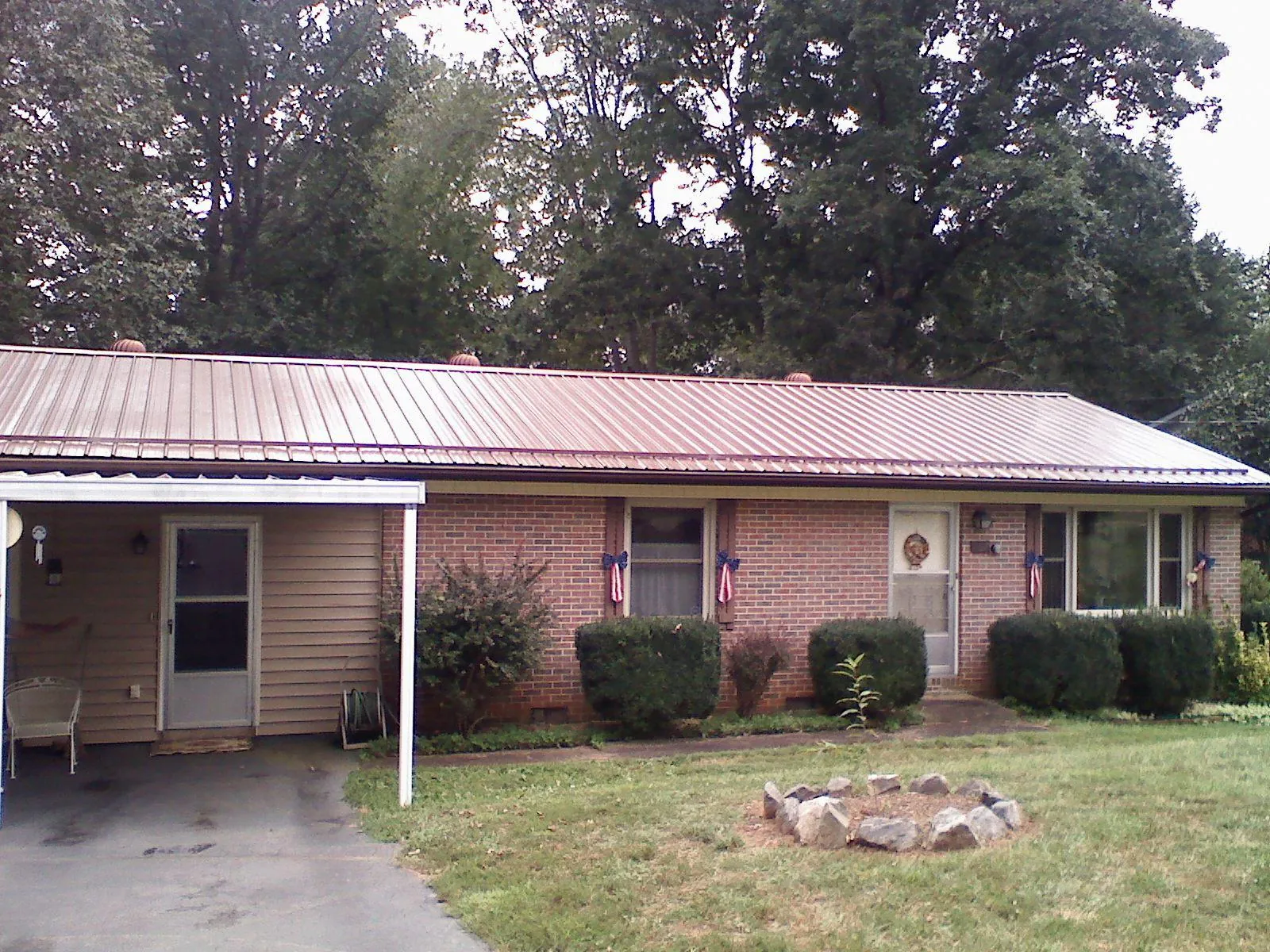Bronze metal roof and carport on a brick ranch home — Roof Repair work by our crew in South Lyme
